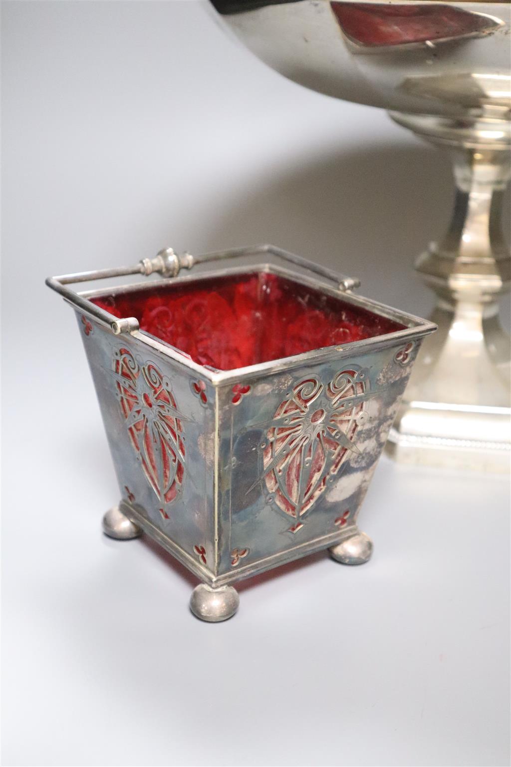 A large silver plated comport, after Christopher Dresser, diameter 33cm, a plated sugar basket with red glass liner and a Victorian pla